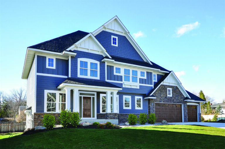 a large house with new james hardie siding in dark blue paint. Keep reading to learn more about the cost for James Hardie siding.