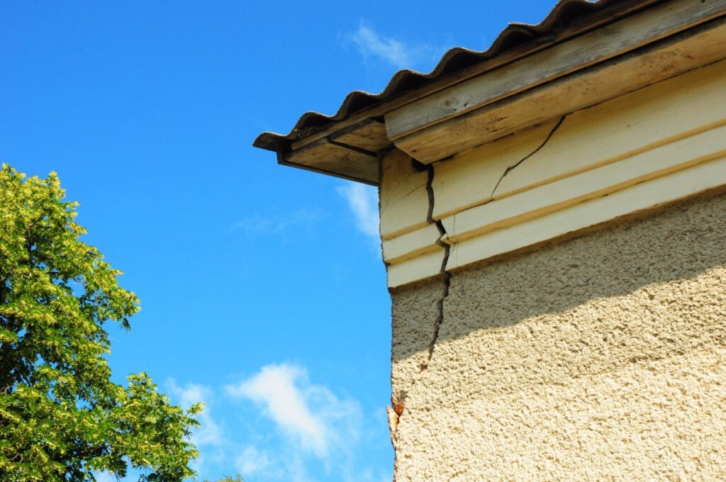 A crack on a stucco house near the roof